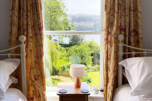 a bedroom with two beds and a window at Riverside Idyll - the perfect Cornish Sanctuary in Truro