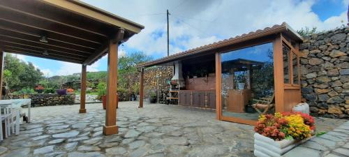 a building with a large window and a stone patio at Casa Elba in Isora
