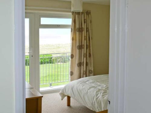 a bedroom with a bed and a large window at Seascape in Lowestoft