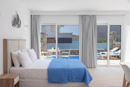 a bedroom with a bed and a view of a pool at Naiades Village Elounda in Elounda