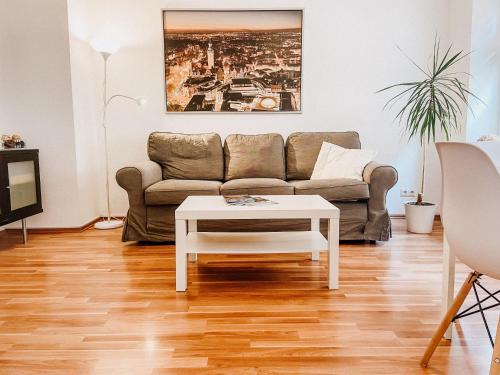 ein Wohnzimmer mit einem Sofa und einem Couchtisch in der Unterkunft Gemütliche FeWo mit Balkon in Leipzig
