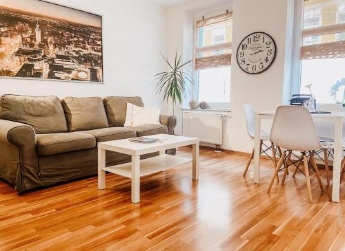 a living room with a couch and a table at Gemütliche FeWo mit Balkon in Leipzig