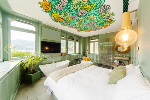 a bathroom with a large bed and a bath tub at Bello!Lake Como Suites in Como