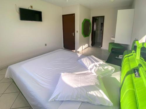 a large white bed in a room with a tv at GUINZA in Balneário Camboriú