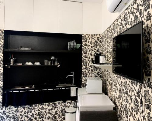 un bagno bianco e nero con lavandino e specchio di Duomo apartment with a view a Firenze