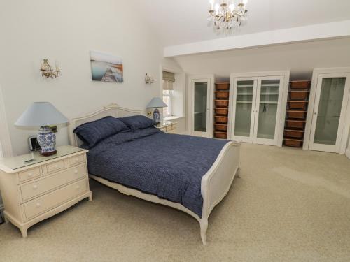 a bedroom with a bed and a dresser and a lamp at Hillside Farm in Kirkby Stephen