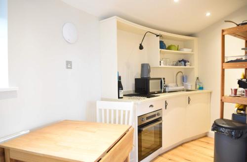 uma pequena cozinha com armários brancos e uma mesa em Isle of Skye Rotunda em Ollach