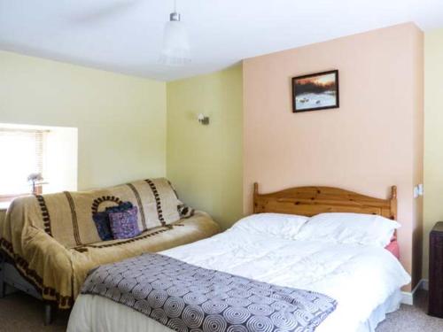een slaapkamer met een bed en een stoel erin bij Ferrys in Portsalon