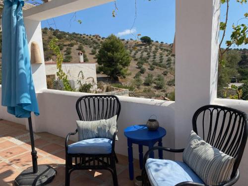 a porch with two chairs and a table with a view at Algarrobo Azul in Almuñécar