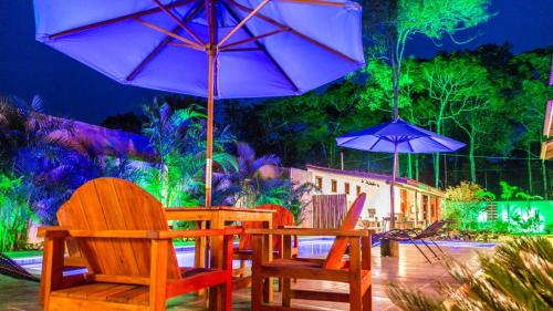 a table and chairs with umbrellas on a patio at Pousada Vila Mangaba in Arraial d'Ajuda