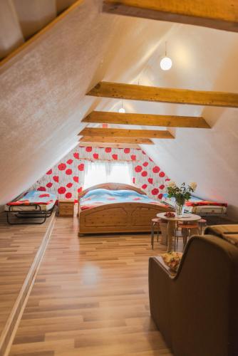 a attic room with a bed and a couch at Villa Magonīte in Ventspils