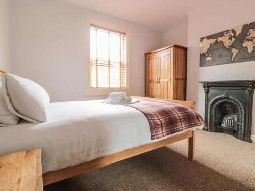 a bedroom with a large bed and a fireplace at 33 Crescent Gardens in Bath