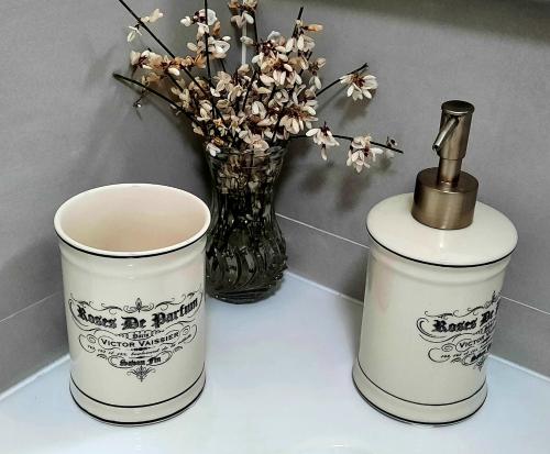 two containers sitting on a table with a vase with flowers at Casa Elba in Isora