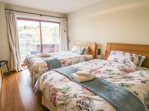 2 camas en un dormitorio con ventana en Boavista, en Carnforth
