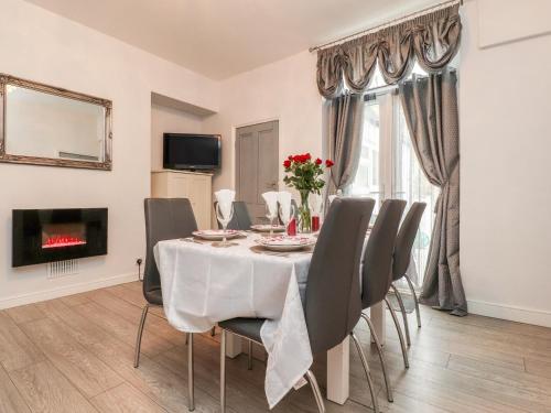 a dining room with a table and chairs and a fireplace at Angel Cottage in Skipton
