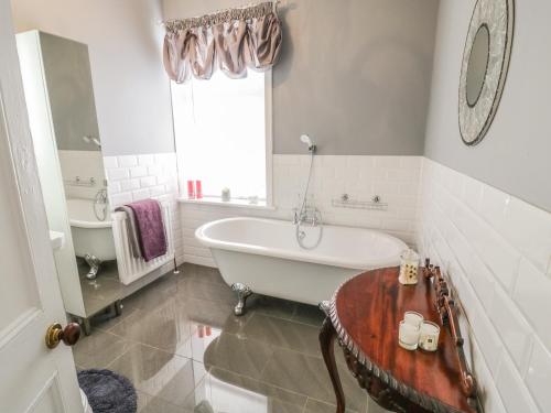 ein weißes Badezimmer mit Badewanne und Waschbecken in der Unterkunft Angel Cottage in Skipton
