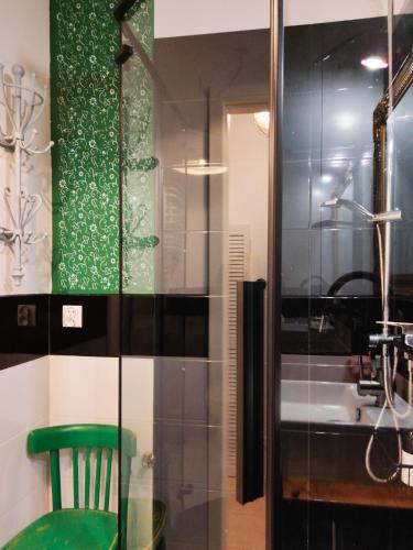 a bathroom with a green chair and a shower at STUDIO KLIMAT PRAGA in Warsaw