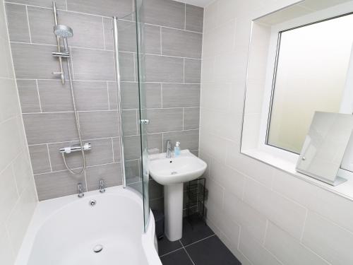 ein Bad mit einer Dusche, einem Waschbecken und einem WC in der Unterkunft Wysteria Cottage in Windermere