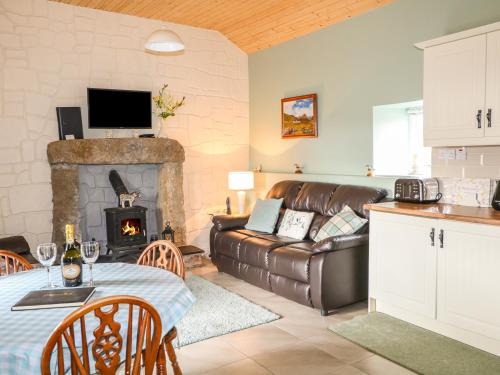 a living room with a couch and a fireplace at Pat White's Cottage in Rostrevor
