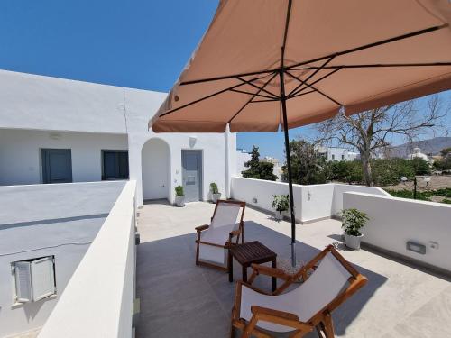 a patio with two chairs and an umbrella at Aerial Apartment in Karterados