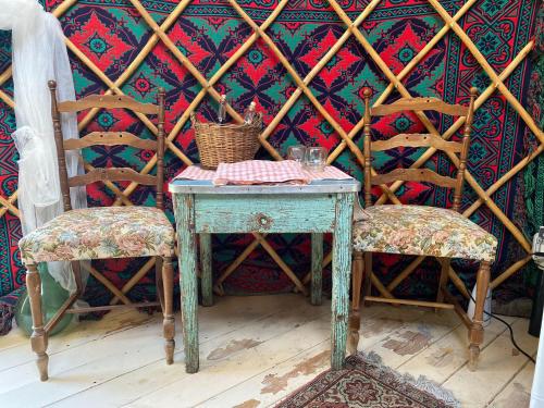 a table and two chairs with a table and a wall at Romantic Yurt in Nature Reserve with Jacuzzi in Anversa degli Abruzzi