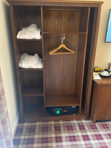 a wooden closet with a hanger and towels at Scone Arms Hotel in New Scone