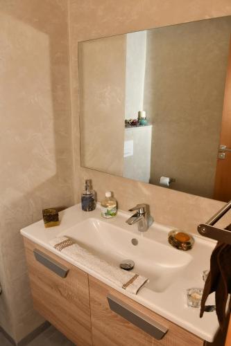 La salle de bains est pourvue d'un lavabo et d'un miroir. dans l'établissement Appartement, à Temara