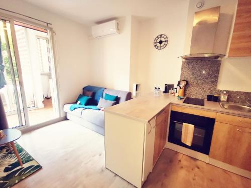 a kitchen with a counter top and a living room at Appartement Ajaccio Sanguinaires in Ajaccio