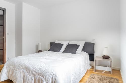 a white bed with two pillows on it in a bedroom at Villa confortable pour 6, St Hilaire-de-Riez in Les Bussolleries