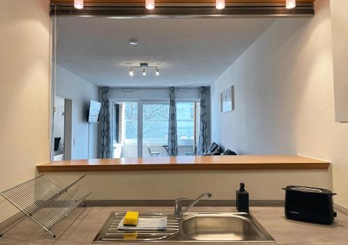 a kitchen with a sink and a mirror at Schönes Apartment im Herzen von Melle I home2share in Melle