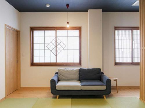 a living room with a couch and a window at Hatsuneso Shinkan in Ureshino
