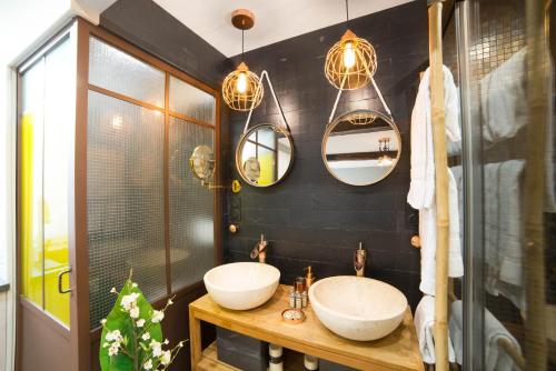 a bathroom with two sinks and two mirrors at The Sweet Luxembourg Garden in Paris