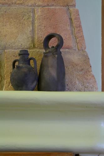 two vases sitting on a shelf next to a brick wall at Ca naleix verdu in Verdú