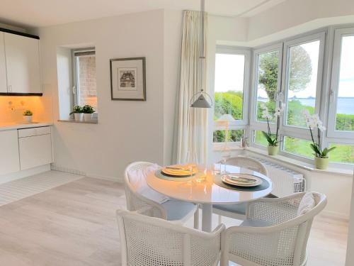 a kitchen and dining room with a table and chairs at Ferienwohnung Strandhüpfer - direkt am Meer in Eckernförde