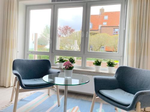 a living room with two chairs and a table and a window at Ferienwohnung Strandhüpfer - direkt am Meer in Eckernförde