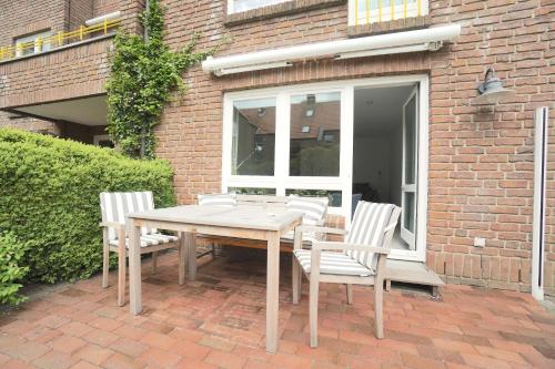 a wooden table and chairs on a brick patio at Ferienwohnung Strandhüpfer - direkt am Meer in Eckernförde