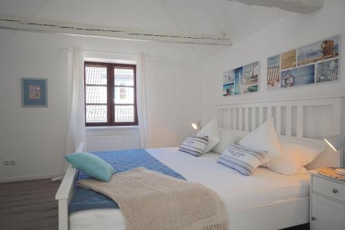 a bedroom with a white bed with blue and white pillows at Ferienwohnung - Unterm Dach in Schleswig