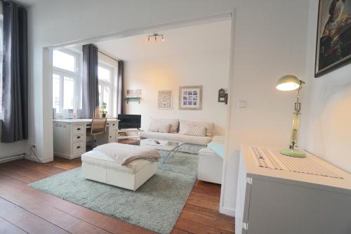 a white living room with a couch and a desk at Ferienwohnung Sprotte am Schleswiger Dom in Schleswig