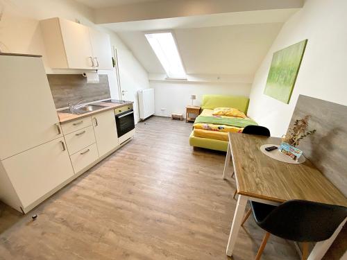 a kitchen and a living room with a bed and a table at Seehaus Mamming - Hotel - Schlaffässer - Biergarten - Camping in Mamming