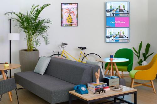 a living room with a couch and tables and chairs at INNSiDE by Meliá Zaragoza in Zaragoza