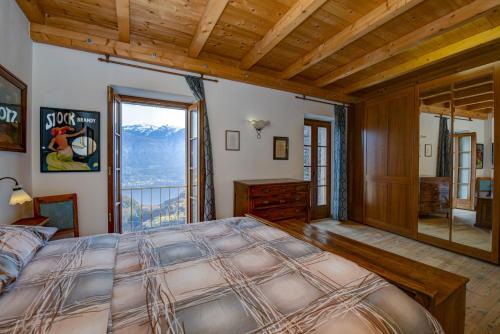 a bedroom with a large bed and a large window at Casa nel Borgo - Casa Oliva in Tremosine Sul Garda
