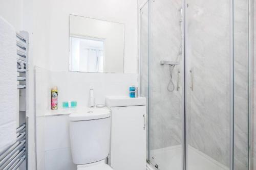 a bathroom with a shower and a toilet and a sink at Stunning 1-Bed Apartment in London Lewisham in London