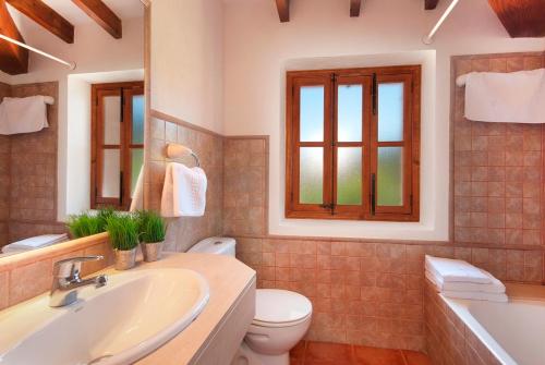 a bathroom with a sink and a toilet and a tub at Villa Cal Apostol in Pollença