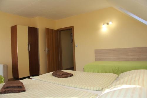 a hotel room with two beds with towels on them at Apartmany Hujer in Bojnice