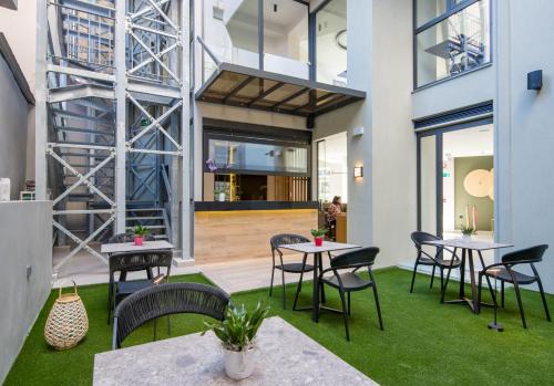 a room with tables and chairs and green grass at M City Hotel in Chania Town
