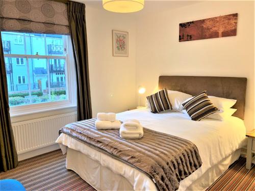 1 dormitorio con 1 cama con 2 toallas en Riverside Channel5 "Holidays Homes in the Sun" Featured Central Canterbury Cottage with Free Parking en Canterbury