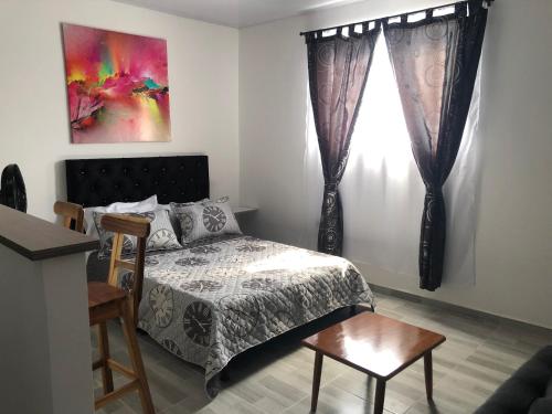 a bedroom with a bed and a window at APARTAESTUDIO Parque Olaya Pereira in Pereira