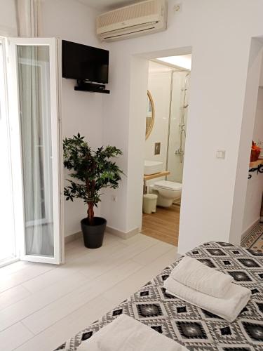 a white room with a bed and a bathroom at Kiki's Apartments in Barbati