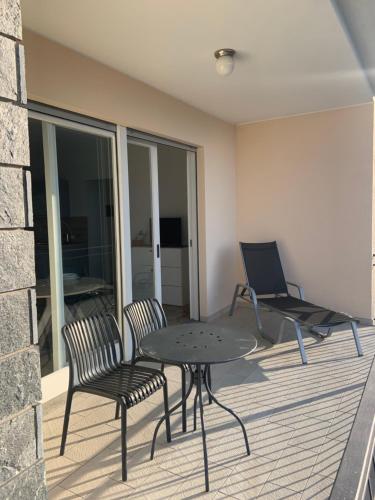 a patio with a table and chairs on a balcony at Casa Colmegna mit traumhaften See- und Bergblick in Luino