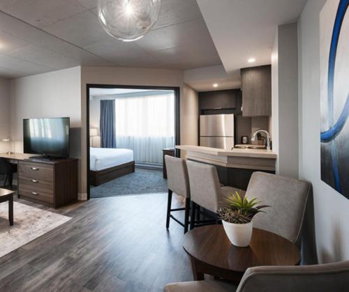 a room with a kitchen and a living room at Imperia Hôtel et Suites Boucherville in Boucherville